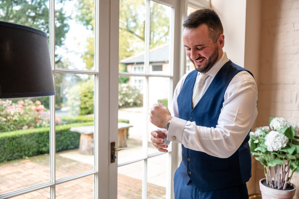 Groom putting on cuff links