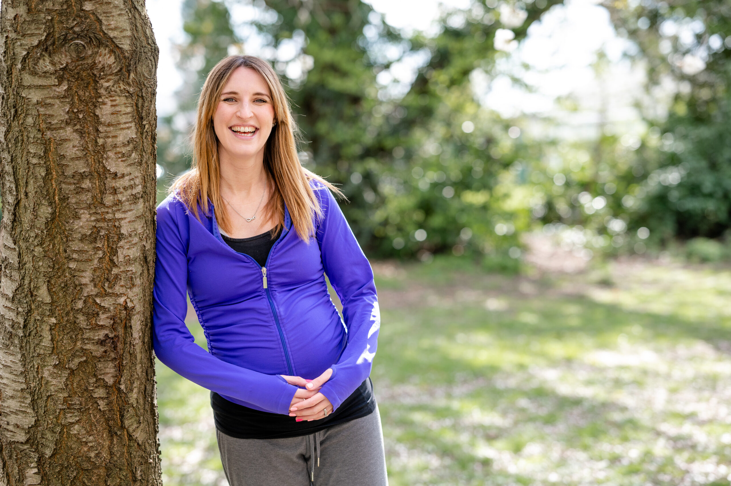 a dance teacher poses by a tree during her watford headshot photoshoot
