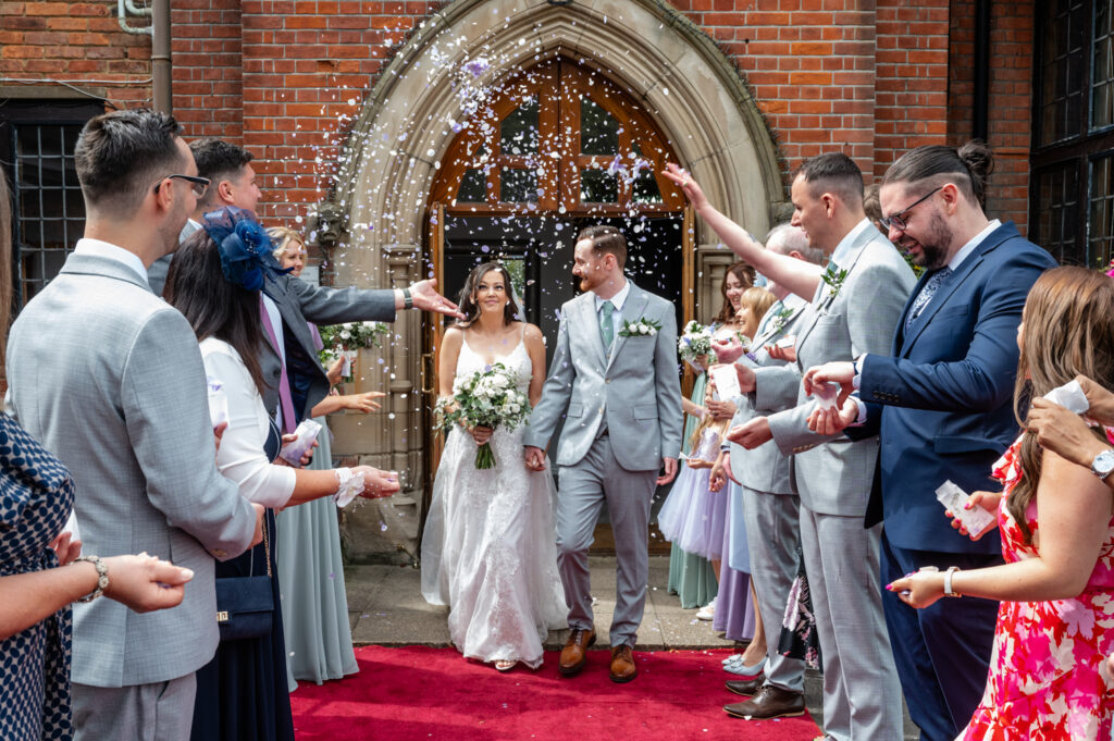 bride and groom on a red carpet for confetti at a golf club wedding