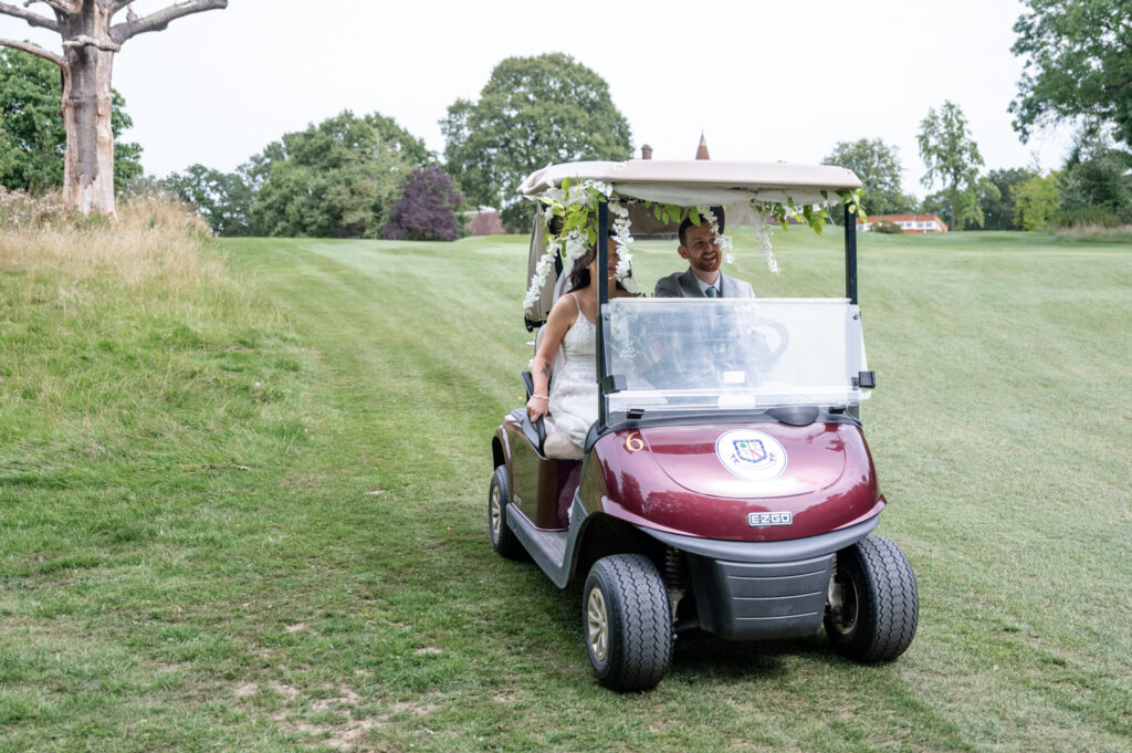 bride and groom in a golf buggy