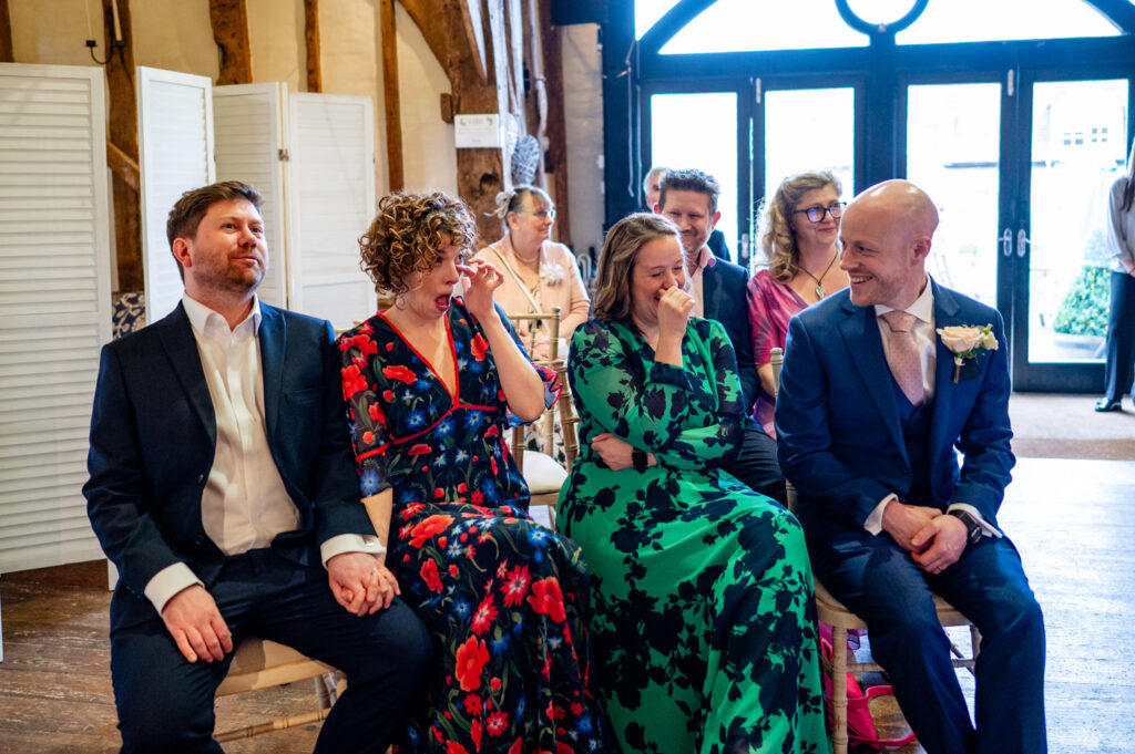 Guests laughing and enjoying the heartfelt moments during Kristin and Simon’s micro-wedding elopement at Old Luxters Barn
