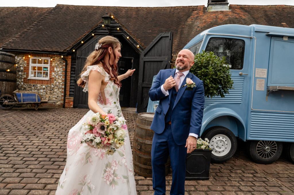 Kristin and Simon laughing and dodging confetti during their unexpected confetti moment at Old Luxters Barn micro-wedding elopement.