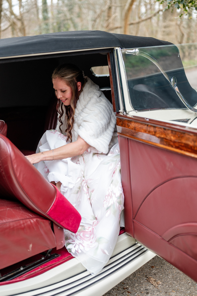 Kristin arriving at Old Luxters Barn in a surprise car for her intimate micro-wedding elopement with Simon, looking joyful and excited.