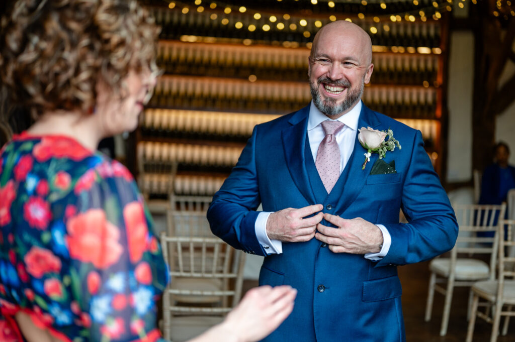 Simon getting ready before his micro-wedding elopement at Old Luxters Barn, looking excited and full of anticipation for the day.
