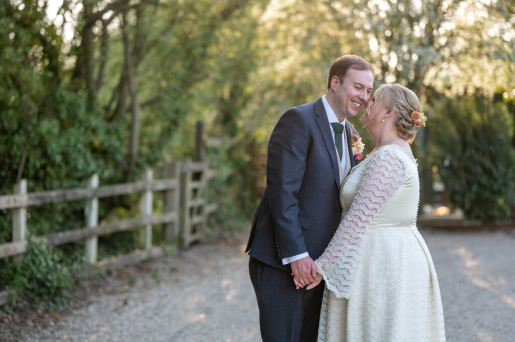 Bride and groom embracing in the evening light at TewinBury Farm.