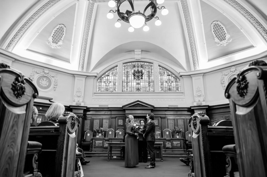 Katie and Will during their micro wedding ceremony in the Council Chamber at Islington Town Hall, London