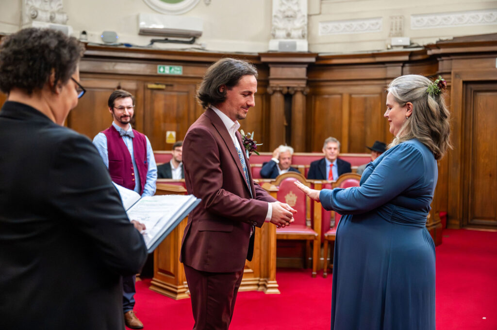 Bride and groom exchanging rings during their Islington Town Hall wedding ceremony