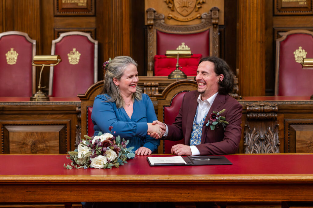 Couple shaking hands during the signing of the register at Islington Town Hall wedding