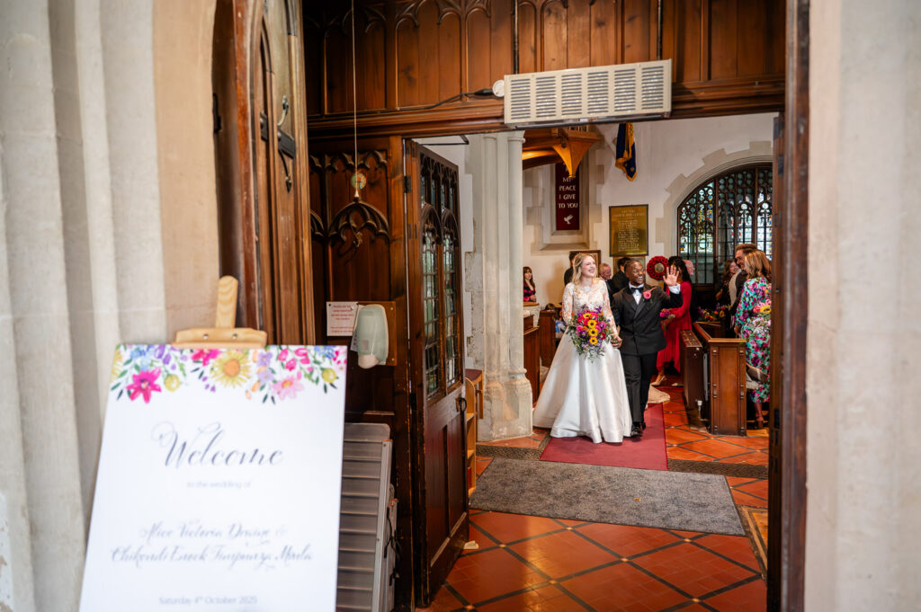 A bride and groom exit St Michaels Church, Chenies after their wedding with photos by As You Are Photography