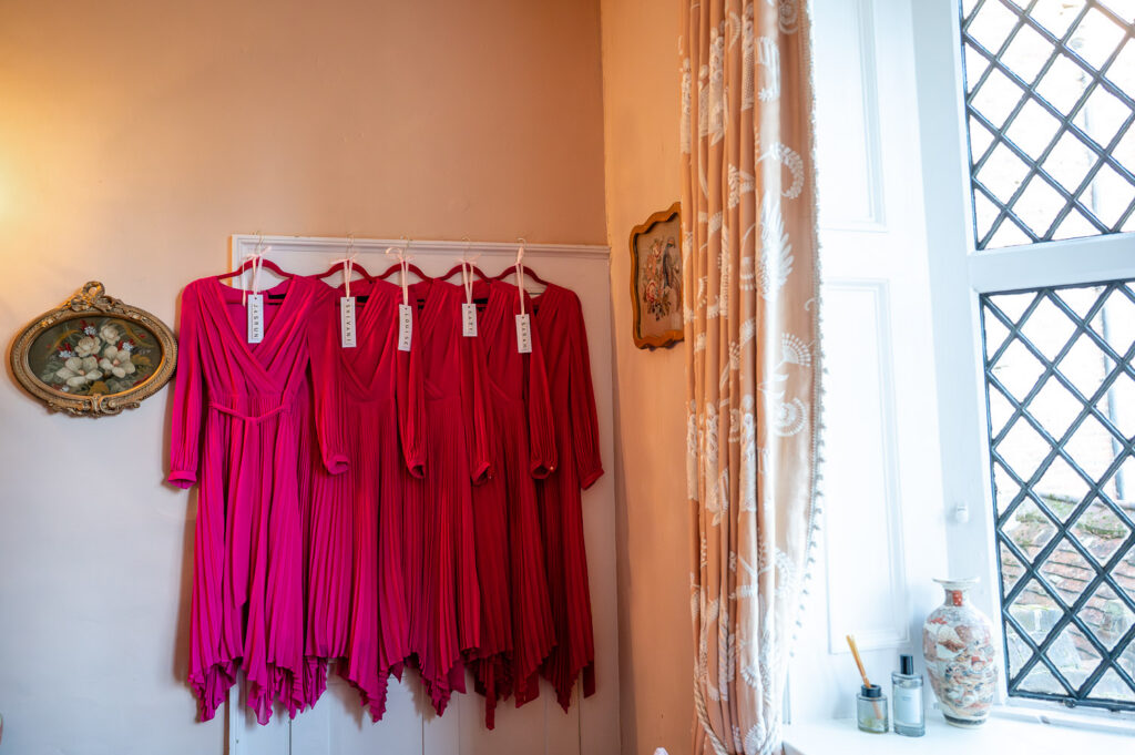 bridesmaids dresses hanging on the door waiting to be worn at Chenies Manor