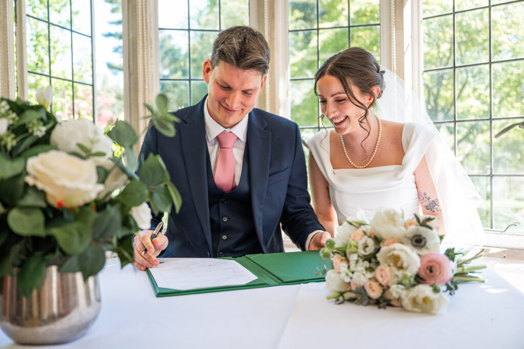 bride and groom sign the register in an Intimate Wedding at Cheslyn House and Gardens 