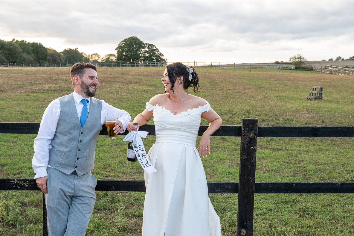 260903Sharna&Adam_LodgeFarm-593 A bride and groom have a relaxed moment to themselves with a drink at Lodge Farm Weddings, Hertfordshire