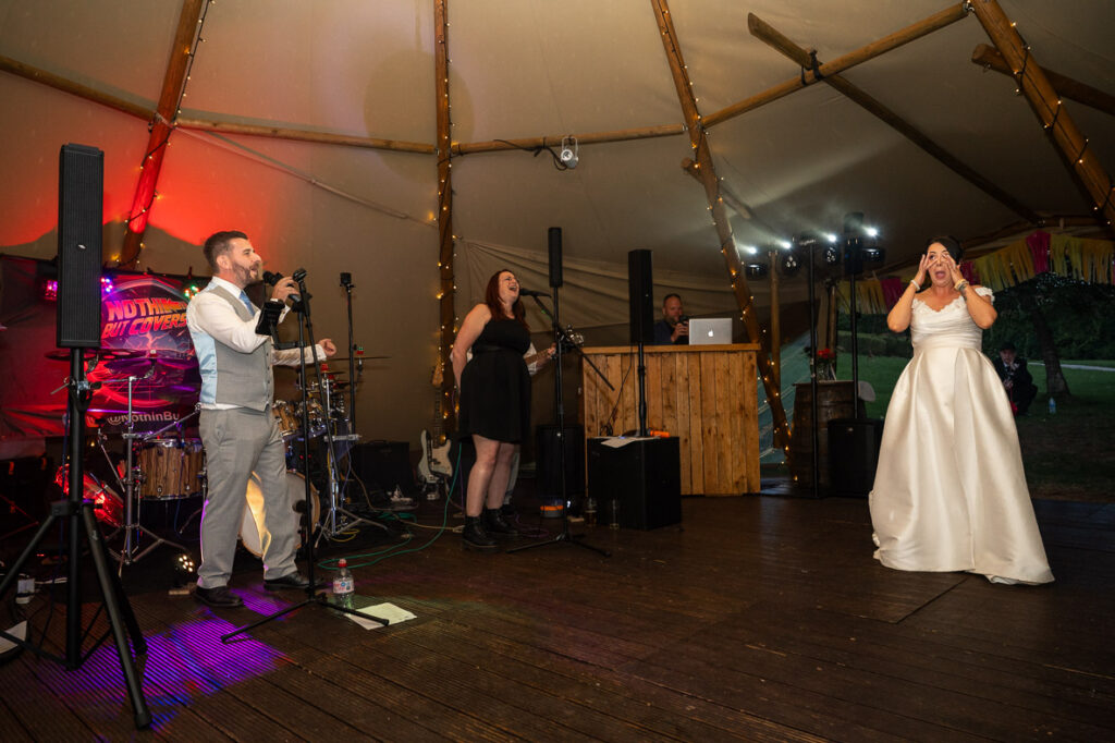 a groom sings a serenade to his new wife at Lodge Farm Weddings, Hertfordshire