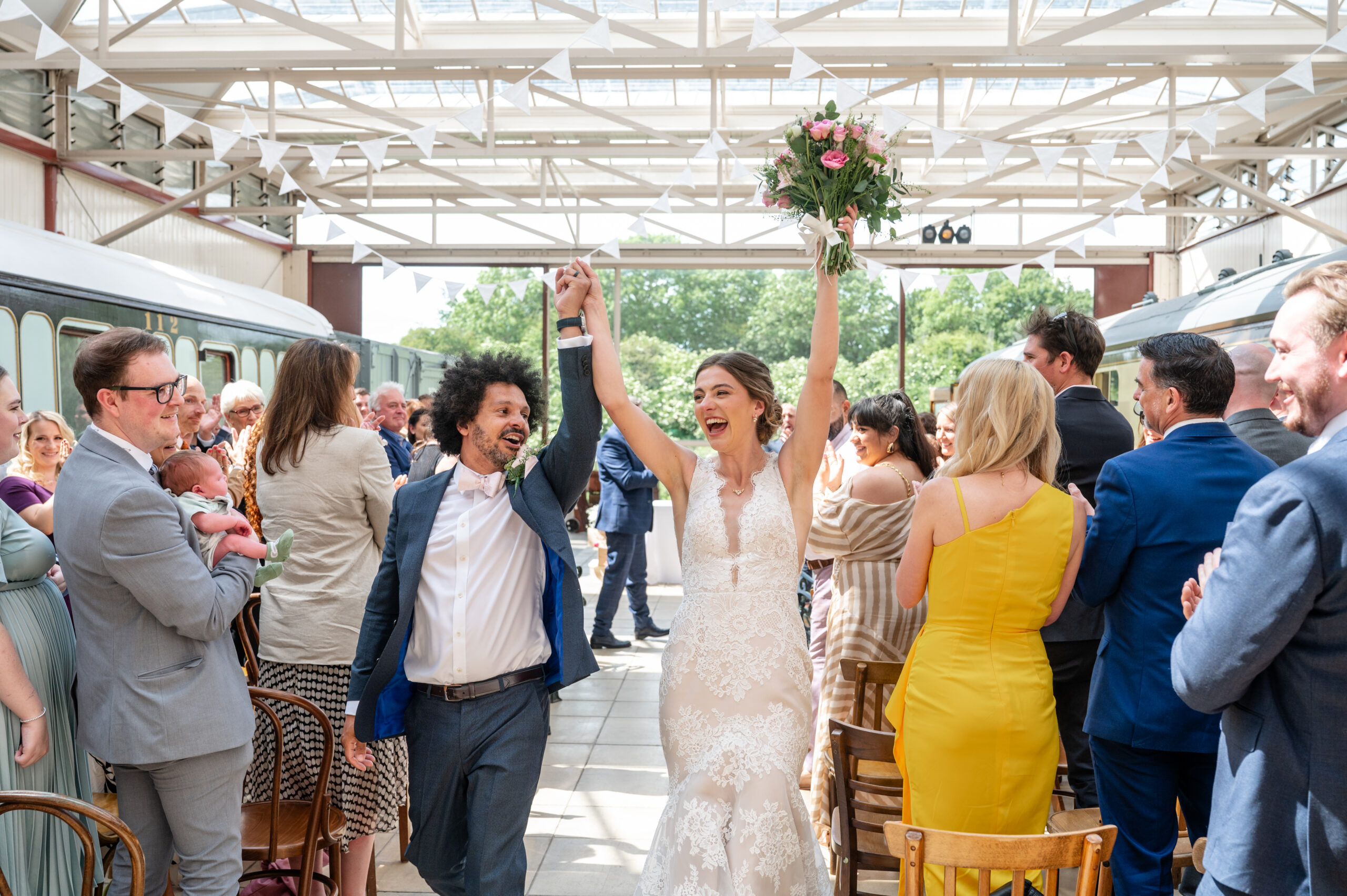 a bride and groom celebrate after their ceremony at Buckinghamshire Railway Centre captured by Hertfordshire Wedding Photographer